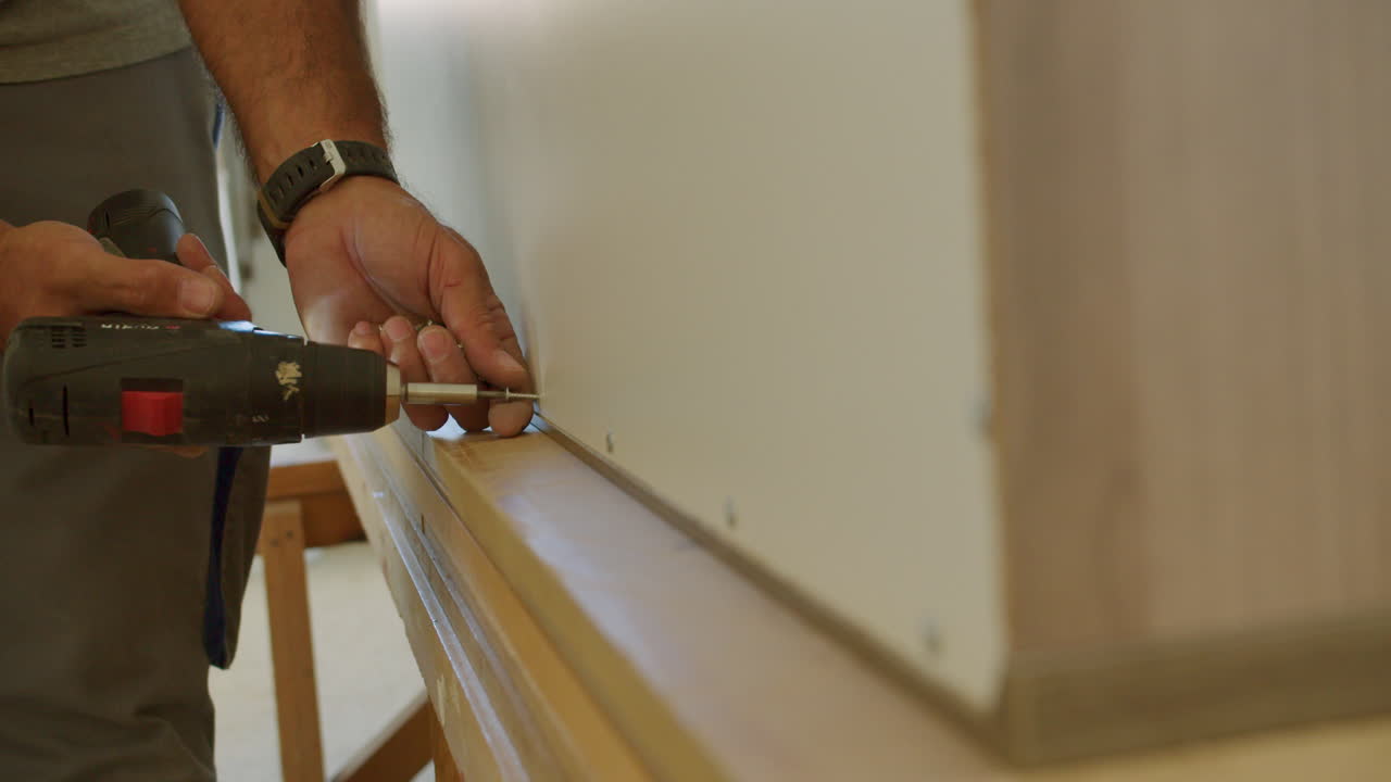 An older man removes screws from a large