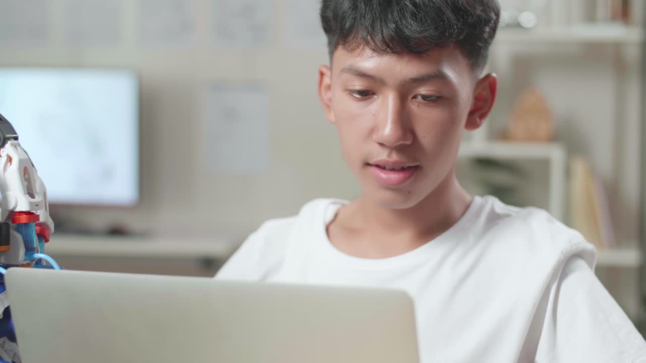 집에서 노트북을 사용하는 사이보그에 대해 일하는 아시아 소년의 클로즈업