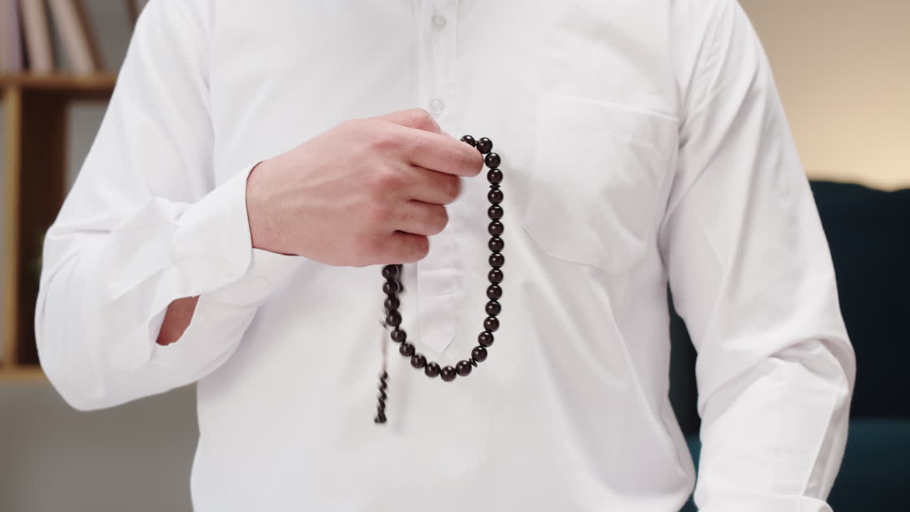 Close-up of a man using Islamic prayer beads (tasbih)