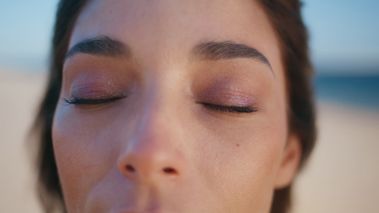 Closeup dark woman eyes gazing at windy shoreline. Portrait model looking camera