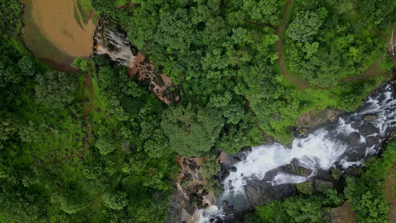 Drone view of a stunning twin waterfall in Bhandardhara, Maharashtra, India. The cascading water flows gracefully amid dense, lush green forest 4K