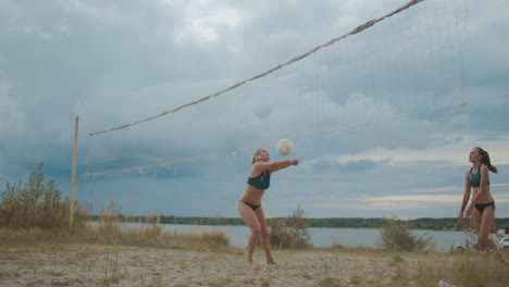 professional team of beach volleyball players women are playing match at sandy court friendly competition and training