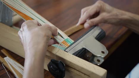 Wooden-stick-being-used-to-separate-colored-yarn