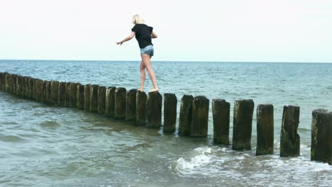 A-young-lady-walking-on-horizontal-lined-trees-into-the-water