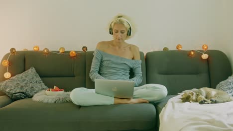 mujer trabajando desde casa en un sofá