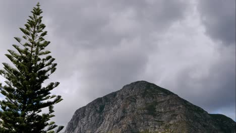 Timelapse-De-Nubes-Moviéndose-Sobre-La-Montaña,-Con-Abeto-En-Primer-Plano