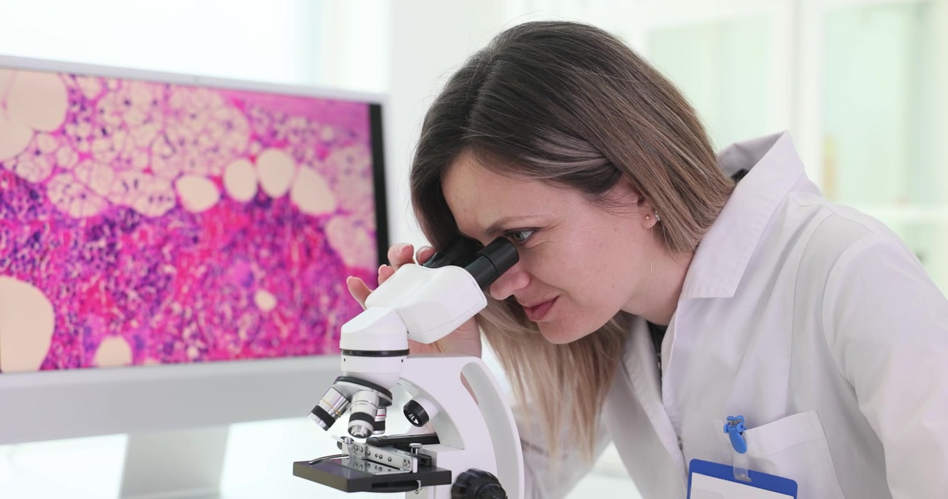 Scienziata esamina attentamente un campione al microscopio