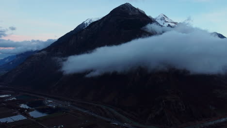 Imágenes-Aéreas-De-Nubes-Matutinas-Frente-A-Picos-Montañosos-Nevados-En-Suiza