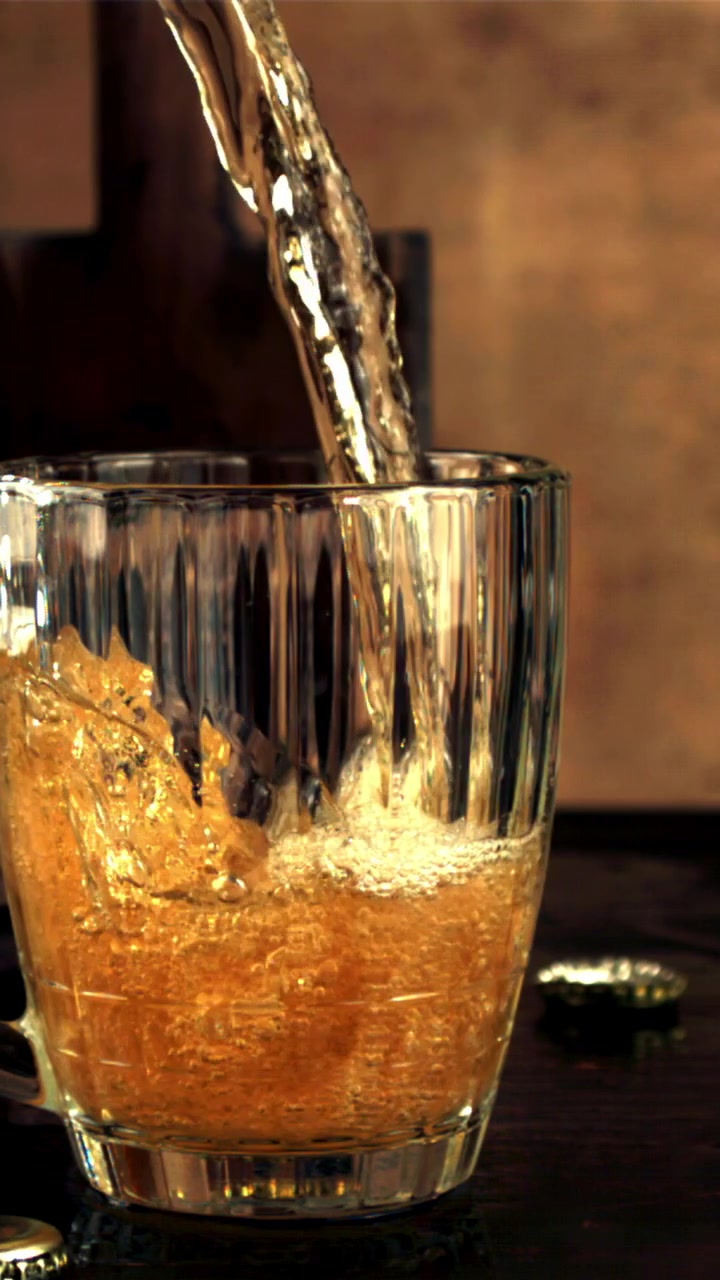 Slow Motion Pouring of Golden Beer into a Glass Mug