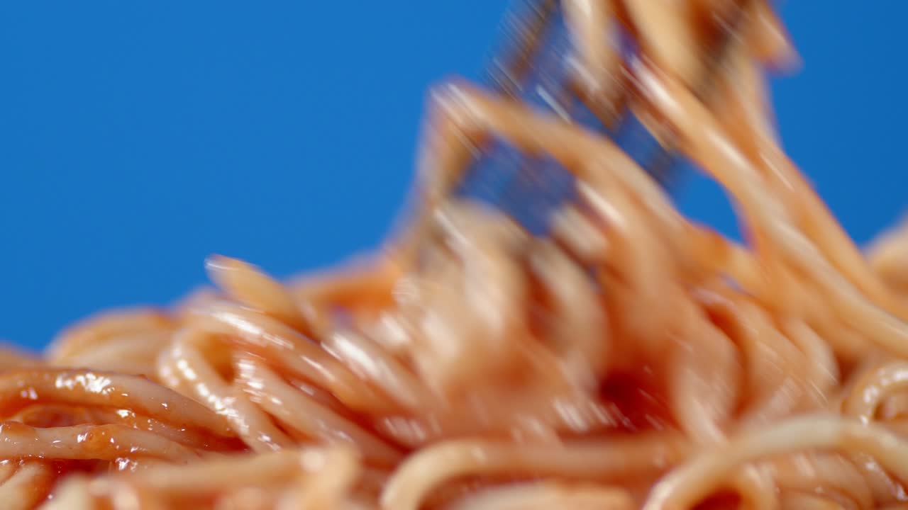 espagueti de pasta hervido con salsa de tomate mezclado con un tenedor.