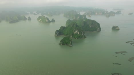 aerial view of numerous limestone islands in a misty bay, reminiscent of halong bay