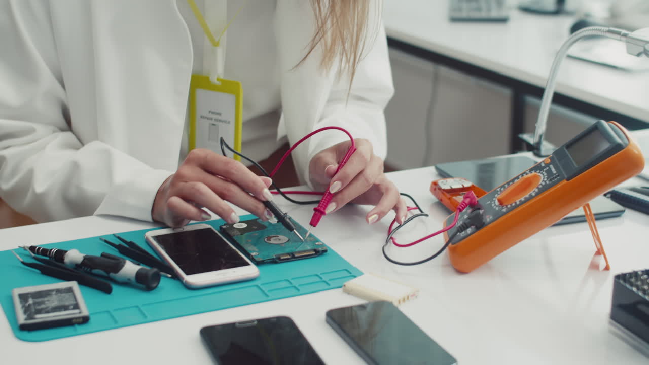 Female Technician Using Multimeter when Working with Broken Hard Drive