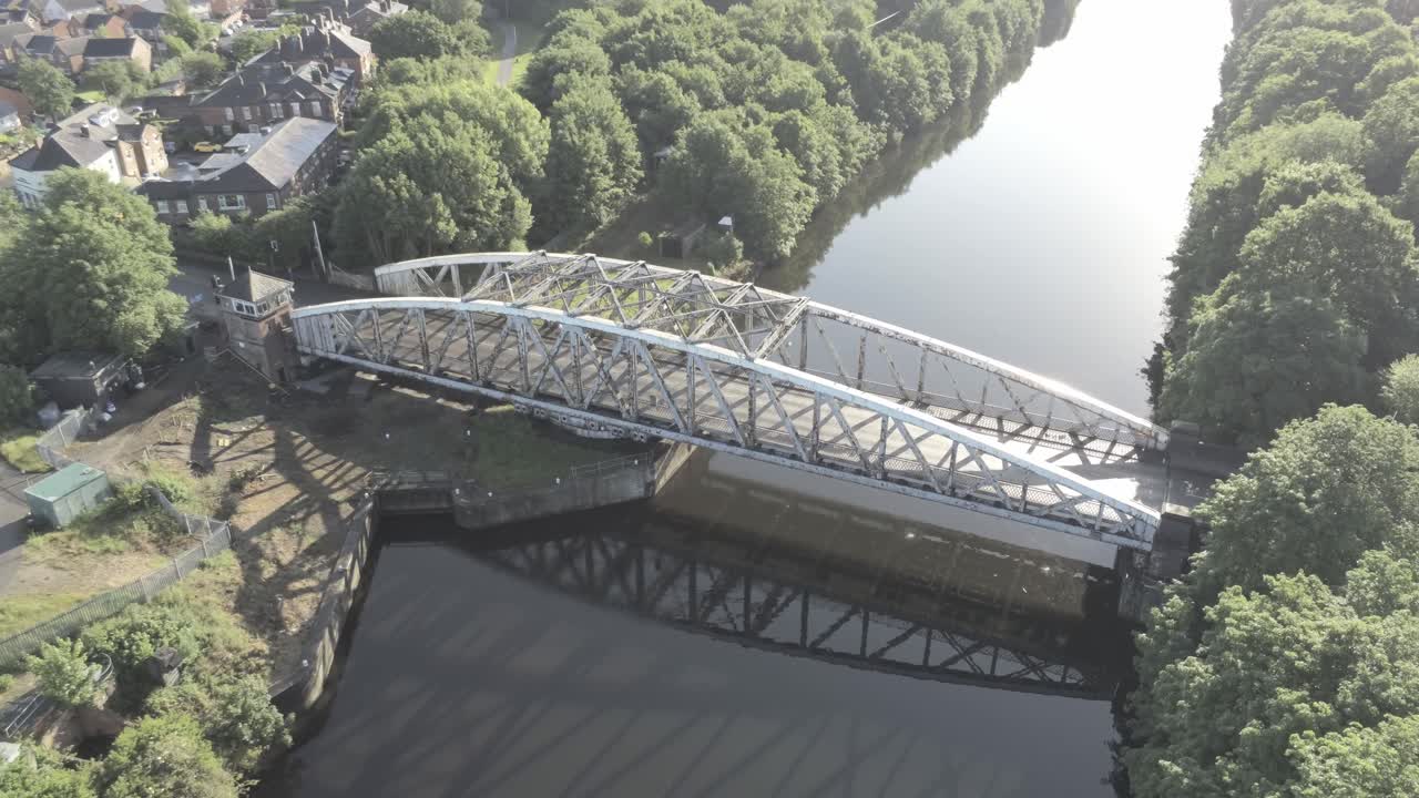 해가 뜰 때 맨체스터 선박 운하 바로 위에 있는 아름다운 구식 강철 아치형 교통 인도교 궤도