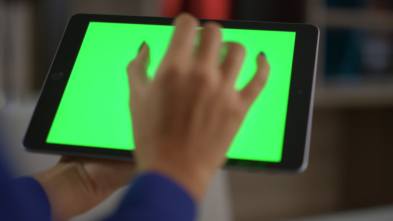 아프리카계 미국인 여성의 손은 사무실에서 태블릿 정보 녹색 화면을 사용합니다.