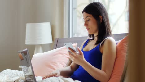 Young-woman-using-laptop-and-mobile-phone-4k