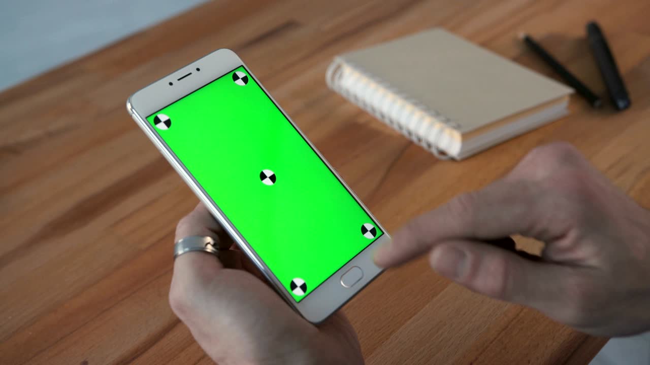 초록색 화면을 가진 전화를 사용하는 남자 손에 들고