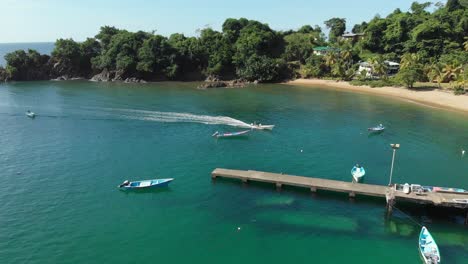 aerial view of a fishing boat returning from a fishing trip to village of parlatuvier, tobago