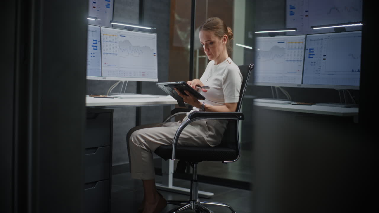 Female Financial Analyst Working on Computer with Multi-Monitor Workstation, Monitoring Real-Time Stocks and Exchange Market Charts. Successful Businesswoman in Financial Agency Office. Vertical Shot.