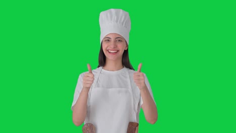 feliz india mujer chef profesional mostrando pulgares hacia arriba pantalla verde