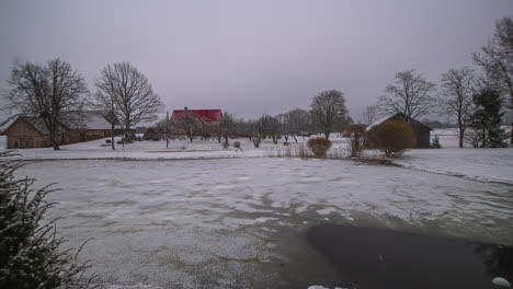 Timelapse---Nubes-Nubladas-Sobre-Casas-De-Campo-Con-Lago-Congelado