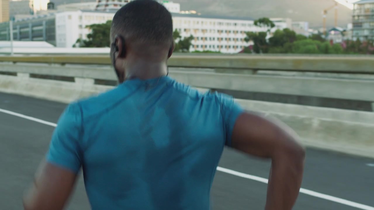 Athletic Man Running on Urban Bridge at Sunset