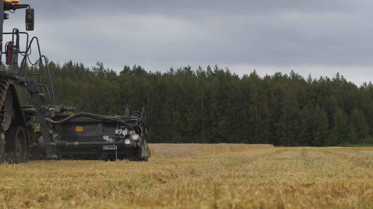 большой трактор собирает пшеницу на большом поле