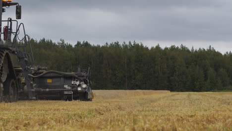 large tractor harvesting wheat in a large field