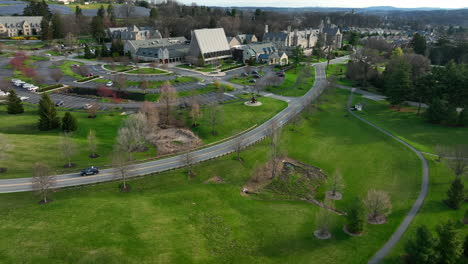 Car-drives-on-road-through-large-estate,-retirement-community-in-USA