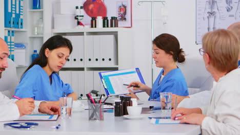 equipo de médicos sentados en la sala de oficinas del hospital de la conferencia discutiendo
