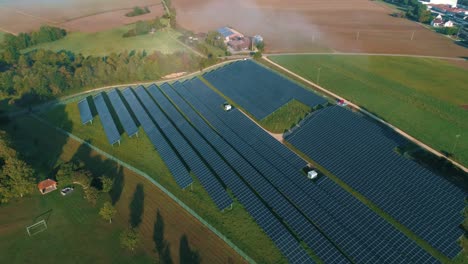 Solar-panels-next-to-green-field-aerial