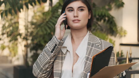 Mujer-Elegante-Haciendo-Una-Llamada-De-Negocios-Al-Aire-Libre.