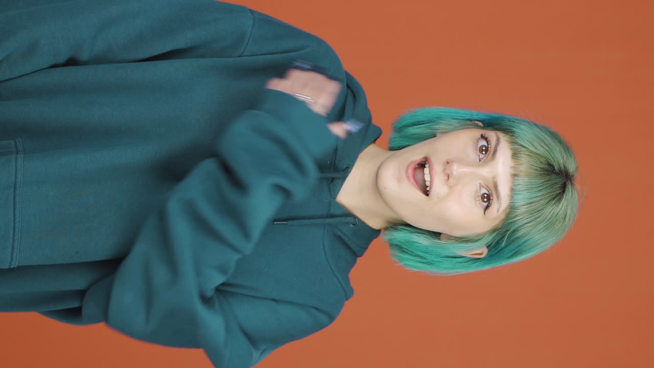 카메라를 놀라게 바라보는 젊은 여성의 수직 비디오.