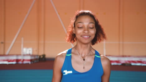 happy sportswoman jumping and cheering to celebrate victory in an indoor sport facility