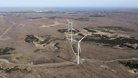 drone shot of a wind farm with spinning wind turbines generating green, sustainable energy