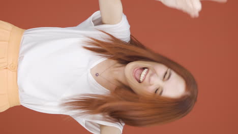 vertical video of woman doing rocker sign and dancing.