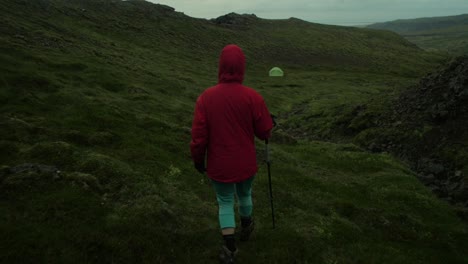 dramatic iceland landscape, person hiking on trail to the tent, camera following movmement, camera tracking - dolly in on a steadicam gimbal stabiliser