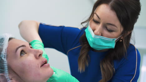 brunette cosmetologist does anti-aging filler injection