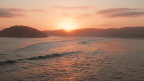 Sunrise-at-the-surf-spots-of-Gerupuk-in-Lombok,-with-a-view-on-the-bay-with-the-fishing-boats-and-surfers