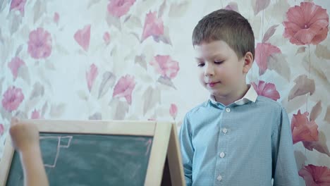 two little brothers paint on easel