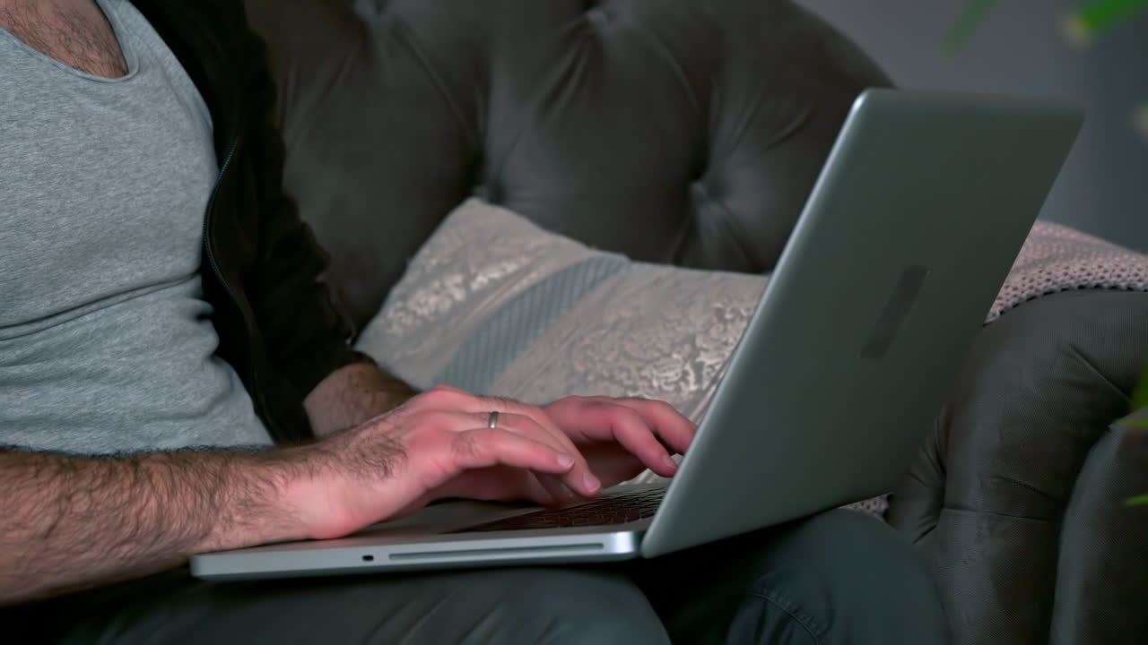 Caucasian man sitting on a chair and working on his laptop
