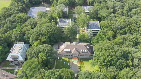 aerial of convention center with small office buildings with solar panels on rooftop in forest