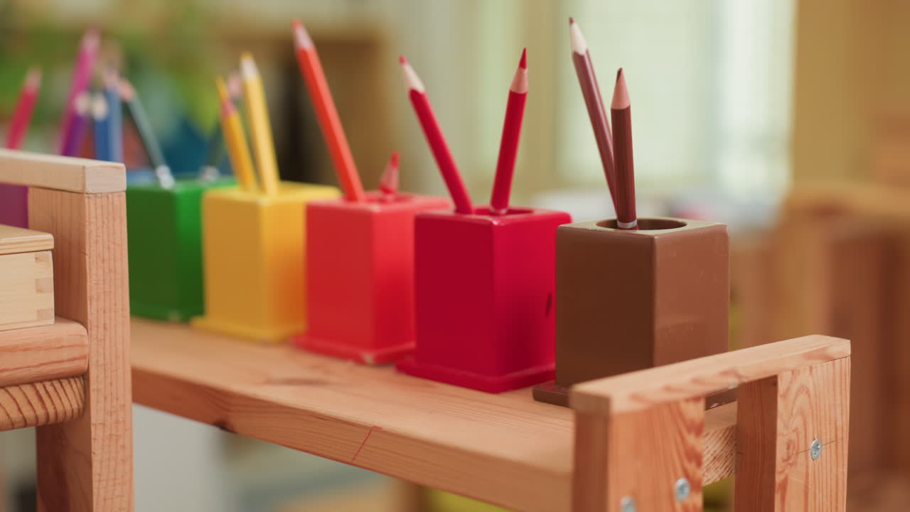 Close up of colorful crayons arranged neatly in red, yellow, green, and brown holders on wooden shelf inside classroom, representing creativity, learning, and vibrant educational atmosphere for kids