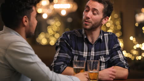 Two-Male-Friends-Enjoying-Evening-Drinks-In-Bar