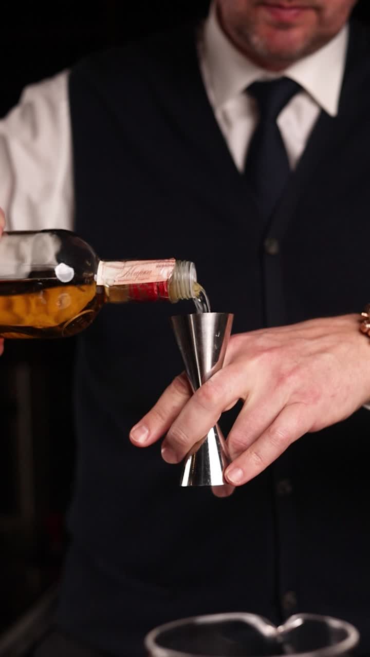 Bartender pouring liquor into a jigger