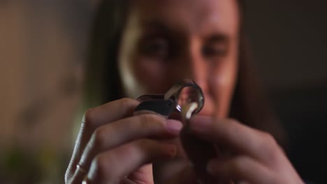 Close-up-of-caucasian-female-jeweller-checking-quality-of-jewelry-in-workshop