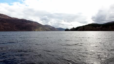 Aerial-view-over-lock-lake-towards-mountain-valley-wilderness-landscape-in-distance