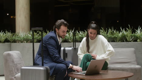 young man and woman working on their laptops in the hotel hall