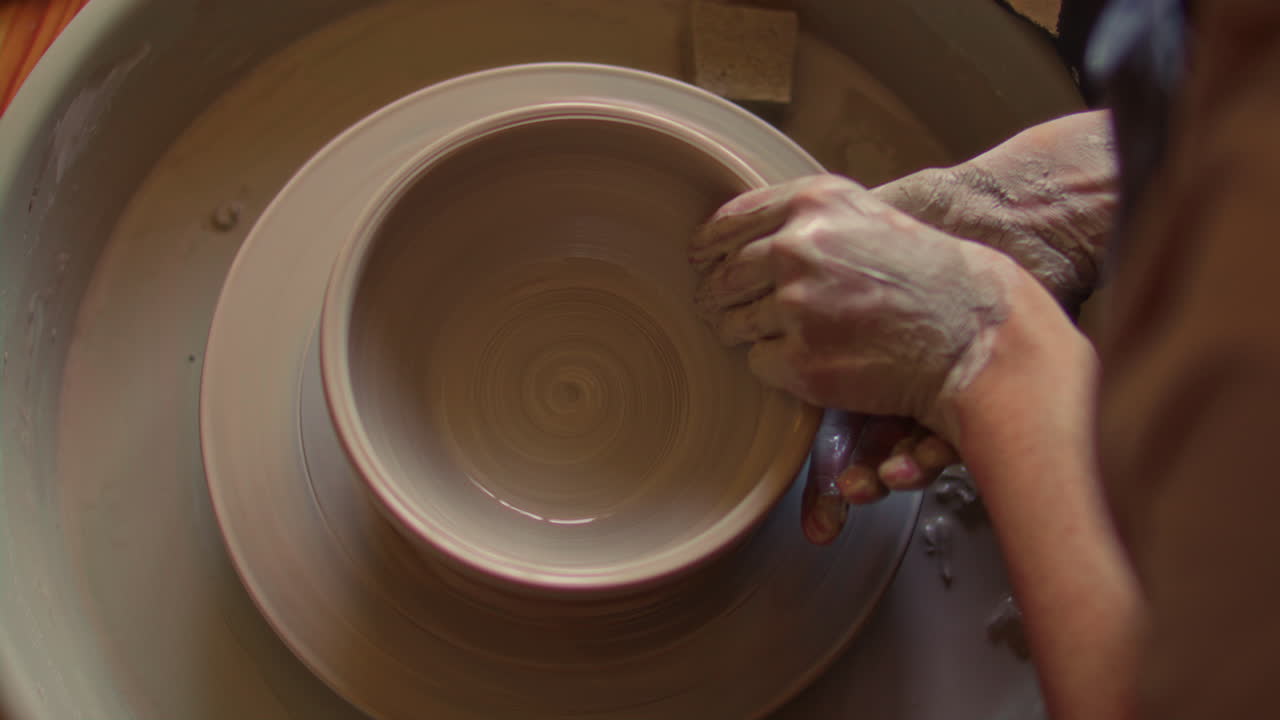 Hands of Ceramic Artist Crafting Clay Bowl on Spinning Pottery Wheel