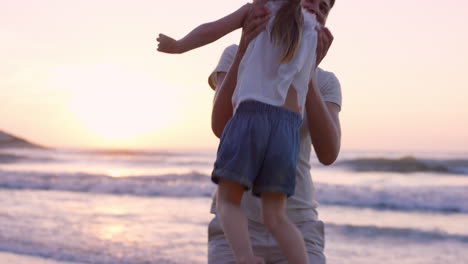 madre balanceando a la niña alrededor de la familia feliz en la playa cogida de las manos al atardecer en vacaciones