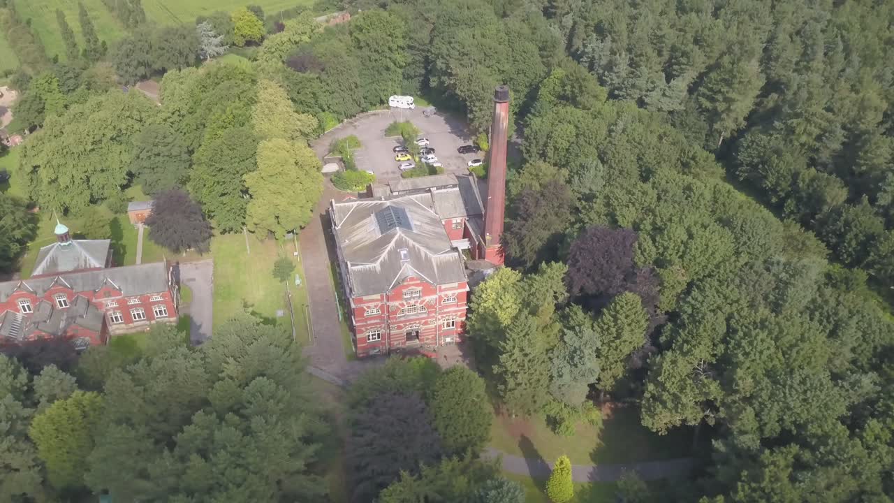 4k drone footage of a brick building in the middle of a forest